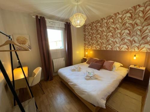 - une chambre dotée d'un grand lit avec deux assiettes dans l'établissement Dahlia YourHostHelper, à Caen