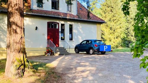 a blue car parked in front of a house at Ferienwohnung Villa am Haussee in Feldberg