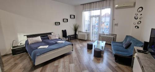 een grote woonkamer met een bed en een bank bij Extra Sok Szobás Apartman Budapest Központjában in Boedapest