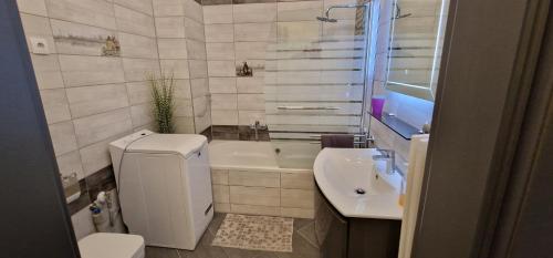een badkamer met een wastafel, een toilet en een bad bij Extra Sok Szobás Apartman Budapest Központjában in Boedapest