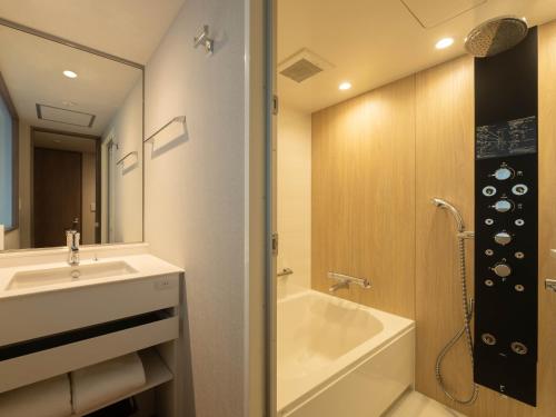 uma casa de banho com um lavatório, uma banheira e um chuveiro em insomnia KYOTO OIKE em Quioto