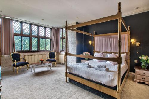 une chambre avec un lit à baldaquin et un salon dans l'établissement Caer Beris Manor By Group Retreats, à Builth Wells