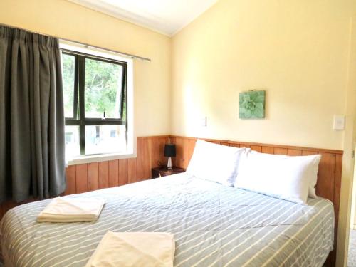 a bedroom with a large bed with a window at Mystery Creek Motel in Hamilton