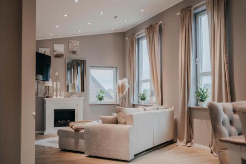 uma sala de estar com um sofá branco e uma lareira em Cottage an der Elbe Tespe Hamburg em Tespe