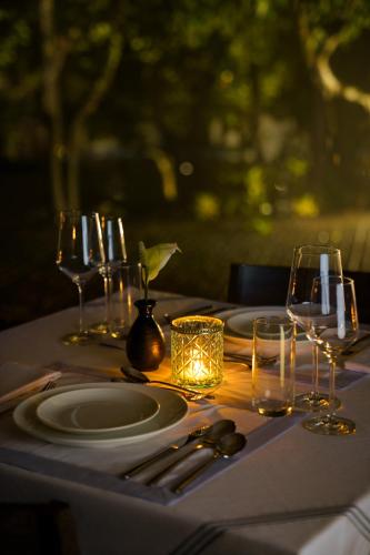 a table with plates and wine glasses on it at Anand Kashi by the Ganges Rishikesh - IHCL Seleqtions in Rishīkesh