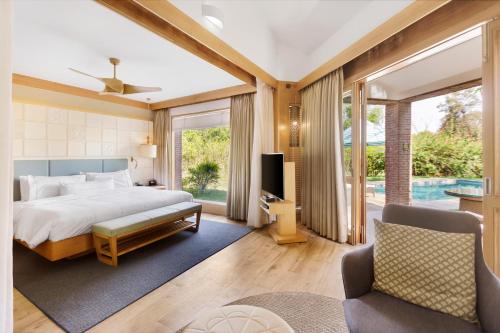 The Westin Sohna Resort & Spa في جورجاون: غرفة نوم مع سرير مزدوج كبير وتلفزيون