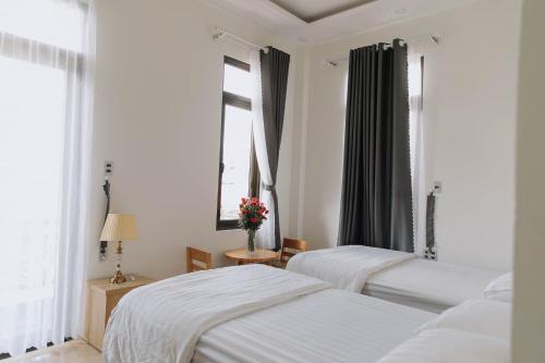 1 dormitorio con 2 camas y ventana en Mai DiaMond Hotel, en Da Lat