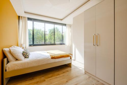 a bedroom with a bed and a window at Chic Flat w Garden Nature View in Kemer in Antalya
