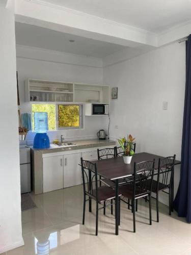 a kitchen and dining room with a table and chairs at Lopez Beach Resort in Sipalay