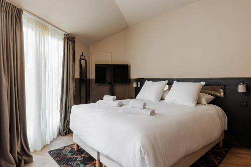 a bedroom with a large white bed with white pillows at La Loge Gogaille - Arago - Accès autonome in Orléans