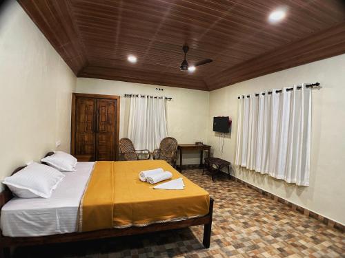 a bedroom with a bed and a desk and a television at Mahout Resort Wayanad - An Experiential Jungle Stay with Waterfall in Kalpetta