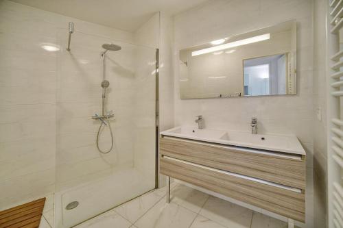 a white bathroom with a sink and a shower at Appartement , piscine, terrasse, proche croisette in Cannes
