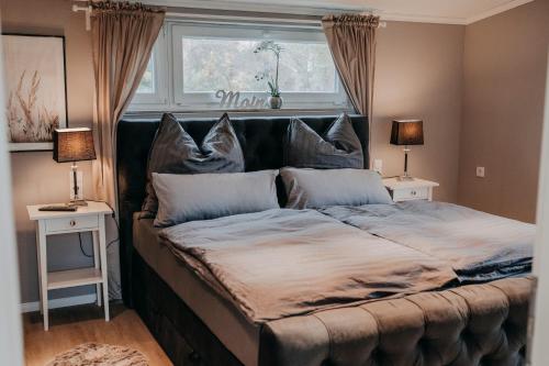 - un grand lit dans une chambre avec deux tables et deux lampes dans l'établissement Cottage an der Elbe Tespe Hamburg, à Tespe