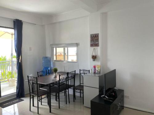 a dining room with a table and chairs and a television at Lopez Beach Resort in Sipalay