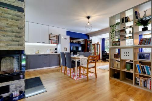 a kitchen and living room with a table and a fireplace at Mały Dąbek in Poddąbie