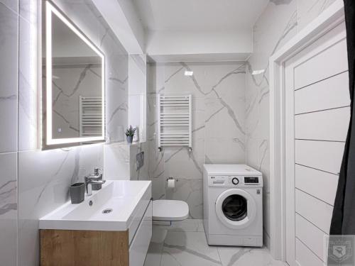 a white bathroom with a washing machine in it at RentHouse Apartments Perla in Chişinău