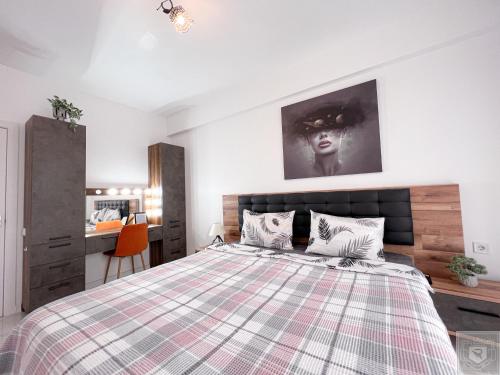 a bedroom with a large bed with a plaid blanket at RentHouse Apartments Perla in Chişinău