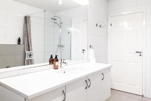a white bathroom with a sink and a mirror at Reykjavík Central Apartments in Reykjavík