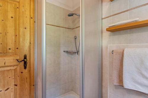 a shower with a glass door in a bathroom at Kranebitterhof Apt Enzian in Valdaora