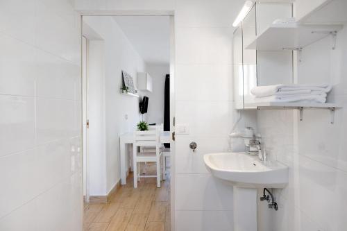 a white bathroom with a sink and a mirror at Casa Gloria in Puerto del Carmen