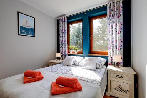 - une chambre dotée d'un lit avec deux oreillers orange dans l'établissement Mały Dąbek I Dom z dostępem do basenu wewnętrznego, zewnętrznego, brodzików dla dzieci, sali zabaw oraz animacji, à Poddąbie