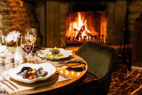 a table with plates of food and a fireplace at Schlössle Hotel - The Leading Hotels of the World in Tallinn