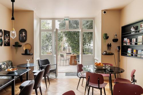 a living room with tables and chairs and a window at La Loge Gogaille - Arago - Accès autonome in Orléans