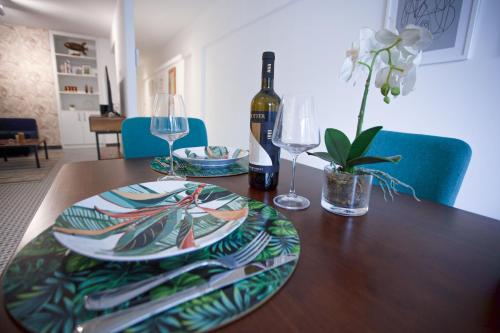 a dining room table with a bottle of wine and glasses at Casa Mercedes in Panama City