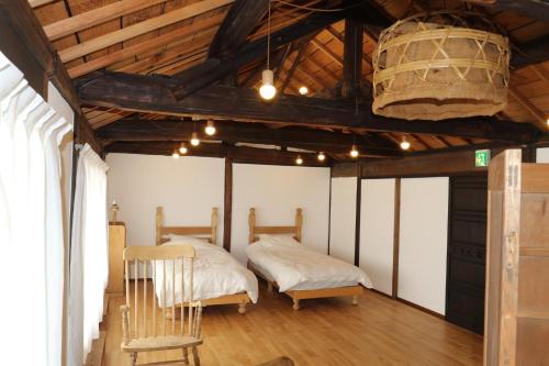 two beds in a room with wooden ceilings and wooden floors at Womb Guesthouse Kojima -Uminomieru ie- - Vacation STAY 95107v in Tamano