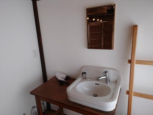 a bathroom with a white sink and a mirror at Womb Guesthouse Kojima -Uminomieru ie- - Vacation STAY 95107v in Tamano
