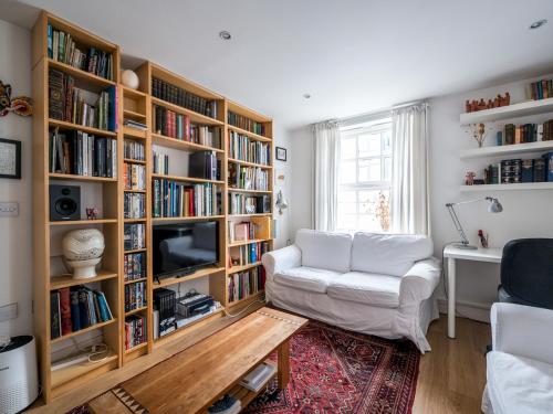 a living room with a white couch and book shelves at Pass the Keys - Modern and spacious flat Near London Bridge in London