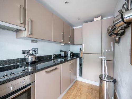 a kitchen with white cabinets and stainless steel appliances at Pass the Keys - Modern and spacious flat Near London Bridge in London