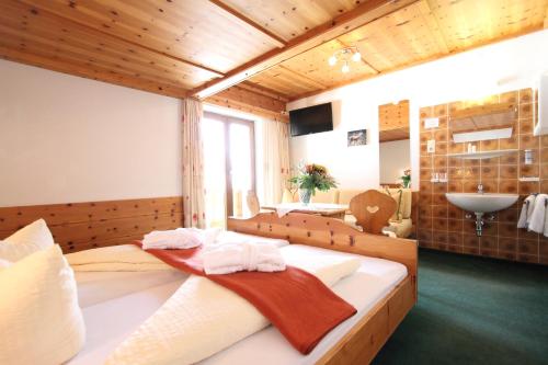 a bedroom with a large bed with a sink in it at Pension Mittagskogel in Sankt Leonhard im Pitztal