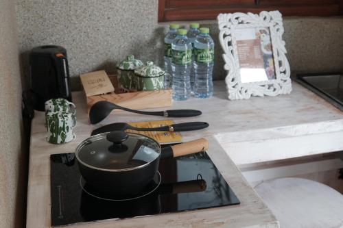 a kitchen counter with a stove with a pot on it at Dusun The Villas in Bawen