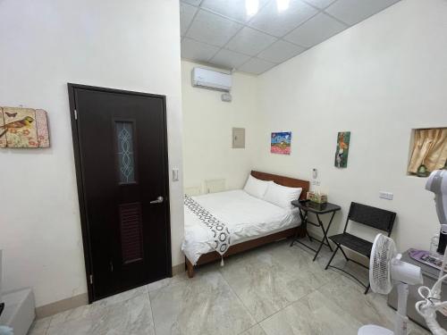a small bedroom with a bed and a door at Happy B&B in Yuli