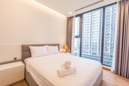 a bedroom with a white bed and a large window at Vinhomes Metropolis luxury Hotel & Residence in Hanoi