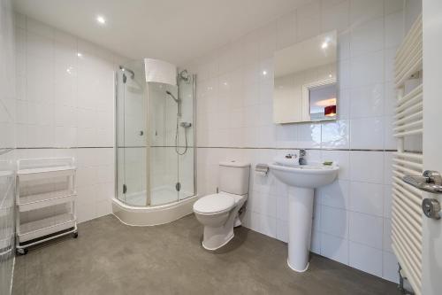 y baño con aseo, lavabo y ducha. en Roomspace Serviced Apartments - The Courtyard Penthouse, en Londres