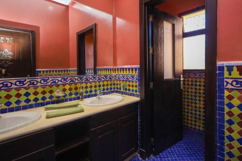 La salle de bains est pourvue de 2 lavabos et d'un miroir. dans l'établissement Mandar Atlas, à Marrakech