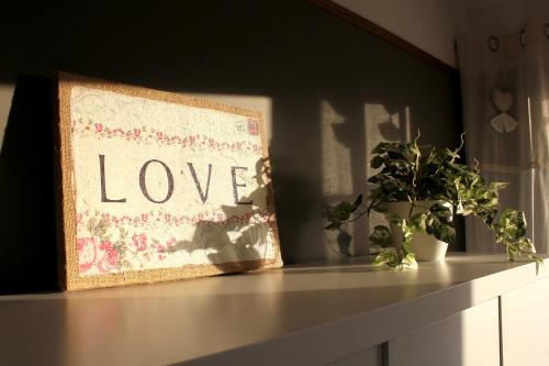 a shelf with a picture of love and plants on it at Connemara luxury apartment in Kinvara
