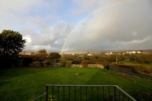 a rainbow over a green field with a rainbow at Connemara luxury apartment in Kinvara