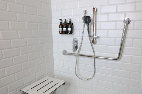 a white bathroom with a shower and a bench at Four Points by Sheraton Mexico City Colonia Roma in Mexico City