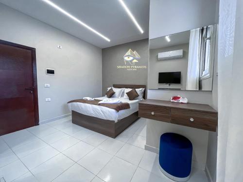a bedroom with a bed and a desk and a television at Shadow Pyramids Suites and Jacuzzi in Cairo