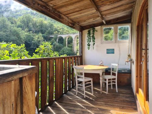 eine Holzterrasse mit einem Tisch und Stühlen darauf in der Unterkunft Gîte Le Chalet in Gourdon