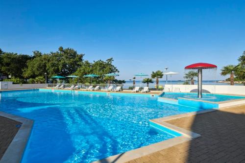 a swimming pool with blue water in a resort at Easyatent Bungalow tent Bijela Uvala in Poreč
