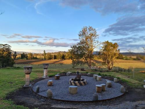 a garden with a fire pit in the middle of a field at Vacy Hunter Valley Lodge in Vacy