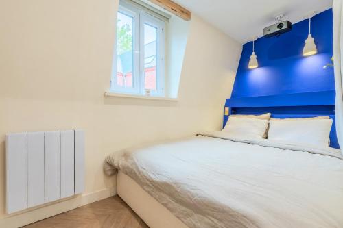 - une chambre avec un mur bleu et un lit dans l'établissement Studio duplex standing centre - Lille aux Bleuets, à Lille