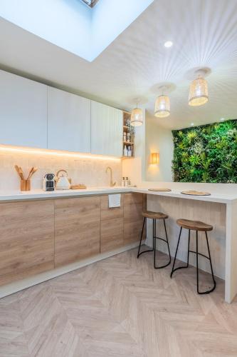 une cuisine avec un grand comptoir et des tabourets dans l'établissement Studio duplex standing centre - Lille aux Bleuets, à Lille