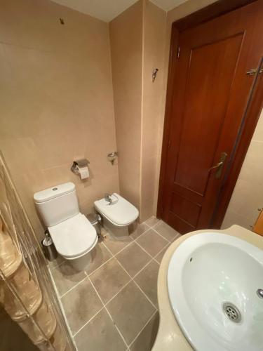 a bathroom with a toilet and a sink at Habitaciones bonitas in Mairena del Aljarafe
