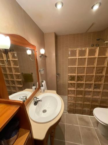 a bathroom with a sink and a shower with a mirror at Habitaciones bonitas in Mairena del Aljarafe