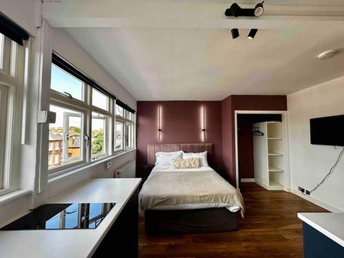 - une chambre avec un lit et une grande fenêtre dans l'établissement Cozy Studio near Regent’s Park N9, à Londres
